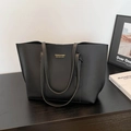 Minimalist large black leather tote bag for women with gold logo and dual shoulder straps - Black
