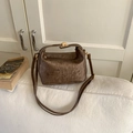 Detail view of dark brown retro handbag featuring vertical pleated texture and gold buckle - Brown