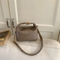 Close-up of taupe textured small handbag with gold hardware and vertical embossed pattern - Khaki