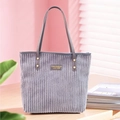 Detalle del bolso tote de pana gris oscuro mostrando textura y parche de logo moda - Gris