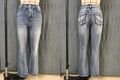 Dettaglio dei jeans a zampa a vita alta con ricamo di croce e ali sulle tasche - S / Blu