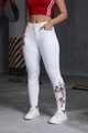 Dettaglio del ricamo floreale colorato sui jeans bianchi slim fit a vita alta da donna - XS / Bianco
