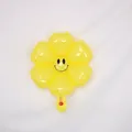 Bright yellow daisy flower foil balloon with a classic black smiley face design - Small Macaron Yellow Smiling Daisy
