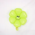 Neon green daisy flower foil balloon with a black smiley face print for parties - Small Macaron Green Smiley Daisy