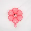 Light pink flower-shaped foil balloon with black smiley face for party decorations - Small Macaron Pink Smiling Daisy