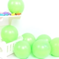 Detail of matte green latex balloons on white display stand for party arch decorations - 10 Inch 2.2g / Fruit Green