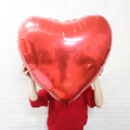 Persona che tiene un grande palloncino a cuore rosso da 32 pollici per matrimoni - Cuore Rosso
