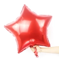 Detail of a 24-inch red star-shaped foil balloon with glossy metallic finish for parties - Red