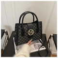 Close-up of vintage tote bag with letter M monogram pattern and gold metal buckle - Black