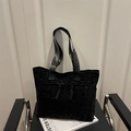 Large black leopard print tote bag with jacquard texture and woven straps on a chair - Black