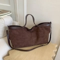 Brown suede tote bag with leather handles in a minimalist indoor setting - Brown