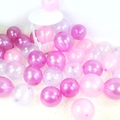 Pearlescent pink and purple latex balloons scattered on a white plush carpet for parties - Rose Red + Purple + Pink