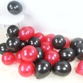 Red and black pearlescent latex balloons on white rug for party decoration - Black + Red