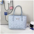 Detail of light blue tote bag featuring pleated texture and golden bow ornament - Blue