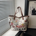 Sac seau blanc avec graffiti d'ours coloré et lanières en cuir marron sous une lumière douce - Blanc
