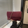 Bolso bandolera de ante sintético burdeos con cadena dorada en ambiente minimalista - Rojo