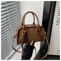 Close-up of brown crossbody bag with suede patchwork, DTN logo, and mini tennis racket charm - Without Pendant / Brown