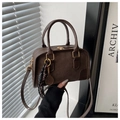 Detail of dark brown leather crossbody bag featuring embossed DTN logo and tennis charm - Without Pendant / Brown