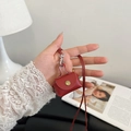 Mini oortelefoontasje van rood leer met kiezeltextuur en gouden drukknoopsluiting - Bordeauxrood