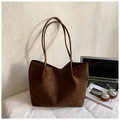 Macro detail of deep brown faux suede tote bag with slim straps and spacious interior - Brown