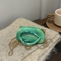 Chic emerald green marble acrylic handbag with gold chain on soft grey fabric - Green