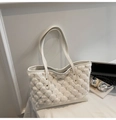 Detail of plush bubble faux fur texture and leather base on a stylish beige bucket bag - White