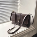 Vintage dark brown faux leather messenger bag with gold hardware on a sunny windowsill - Brown