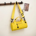 Yellow canvas cylinder duffel bag with smiley zipper and adjustable strap on a wall hook - Yellow