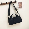Minimalist black cylinder sports duffel bag hanging on a hook with travel accessories - Black