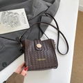 Dark brown woven bucket bag with a wooden button and long shoulder strap for women - Brown