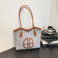 Sac fourre-tout chic texturé avec finitions en cuir marron et logo B sur un bureau - Bleu