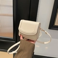 Minimalist cream white leather crossbody flap bag with gold hardware held by a model - No Pendant / White