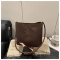 Primer plano del bolso saco de ante marrón oscuro con bordado sobre manta de punto - Café