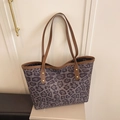 Große Shopper-Tasche mit lila Leopardenmuster, braunen Ledergriffen und Goldnieten - Schwarz