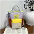 Detailed view of colorful canvas bucket bag with patchwork design and utility pockets - Yellow and Orange
