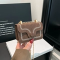 Braune Wildleder-Umhängetasche mit Stickerei und Goldkette in der Hand gehalten - Braun