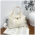 Close-up of off-white nylon handbag with metal logo on aesthetic magazine background - Off White
