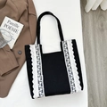 Black canvas tote bag with white lace trim and minimalist shoulder strap design - Black