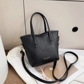 Bolso tipo cubo negro clásico con textura de cuero y logo de moda en relieve dorado - Negro