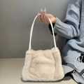 Dettaglio di borsa in peluche beige con eleganti cinturini in pelle bianca per l'autunno - Bianco avorio