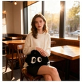 Sac en peluche noir avec des yeux de dessin animé et une chaîne dorée porté par une femme - Noir