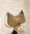 Nahaufnahme der khakifarbenen Satteltasche aus Kunstleder mit goldenen Metallbeschlägen - Khaki