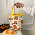 Detailed close-up of a mini canvas bucket bag featuring cute orange cartoon tiger prints - Tiger Yellow