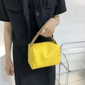 Vibrant yellow minimalist square handbag with tan top handle shown in a hand-held pose - Yellow
