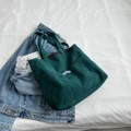 Bolso tote minimalista de pana verde oscuro con etiqueta FASHION sobre fondo denim - Verde