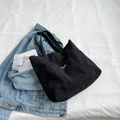 Bolso tote minimalista de pana negra con etiqueta Fashion en un ambiente informal y casual - Negro