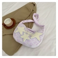 Detail of lavender crescent bag featuring plush star patches and textured fabric - Purple