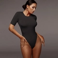 Detail of black short sleeve bodysuit showing high-stretch fabric and slim fit on model - S / Black