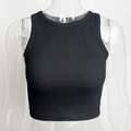 Close-up of black ribbed knit crop top featuring slim fit and racerback detail on a model - S / Standard / Black