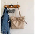 Detalle del bolso tote beige de nailon con cordón ajustable y accesorios de moda - Caqui
